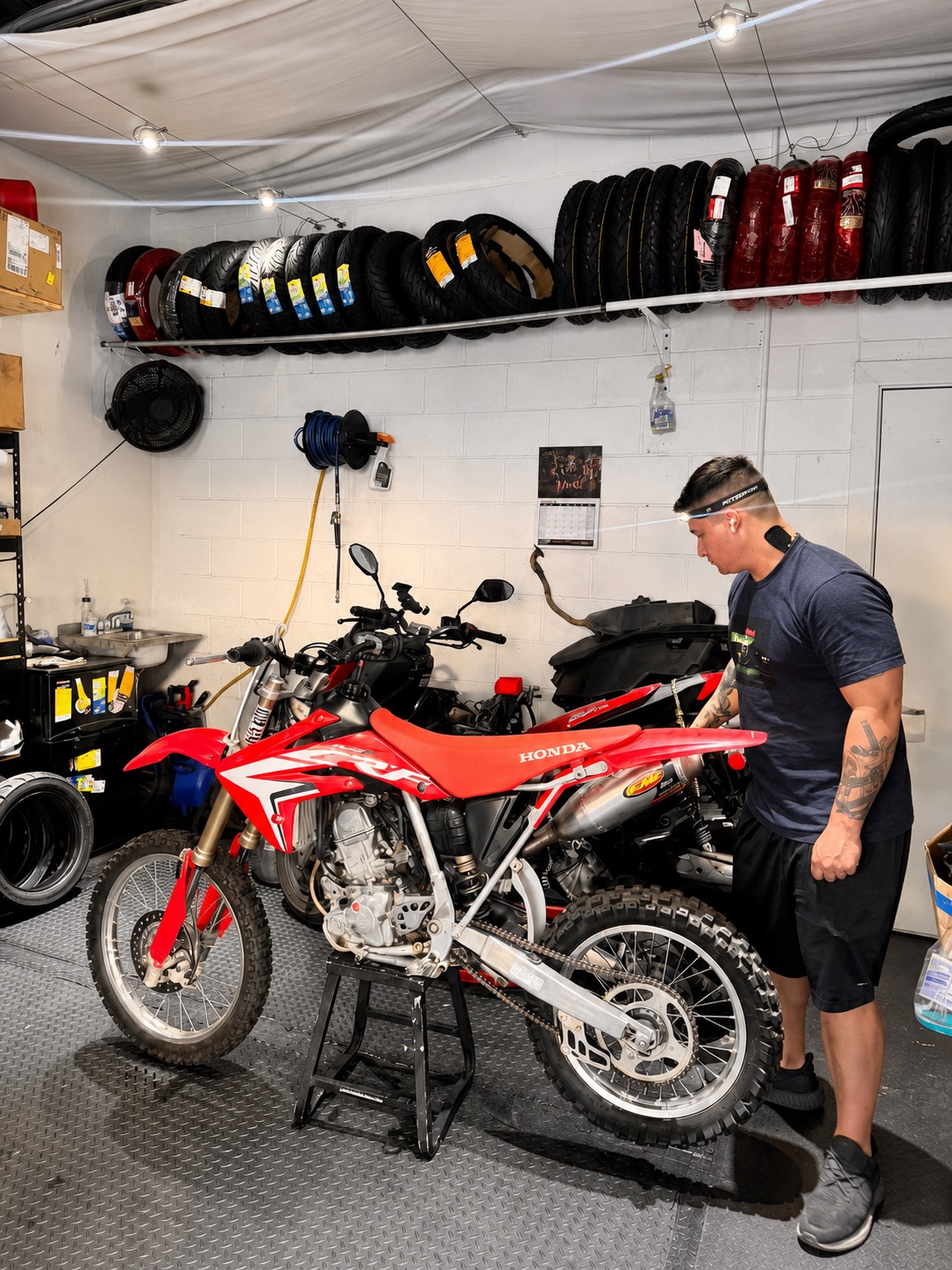 Real Facts mechanic inspecting a red Honda off-road motorcycle